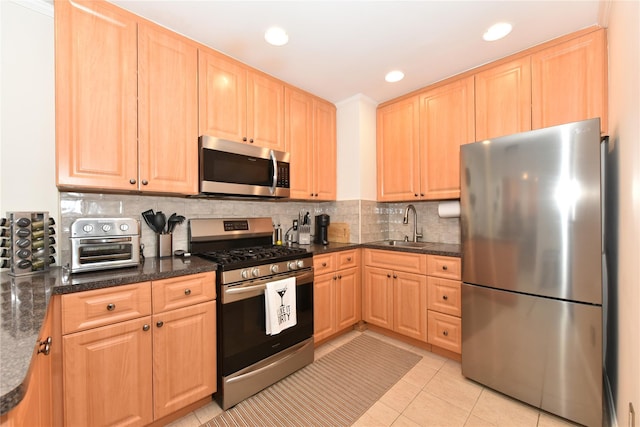 kitchen with stainless steel appliances, tasteful backsplash, light tile patterned flooring, and light brown cabinets