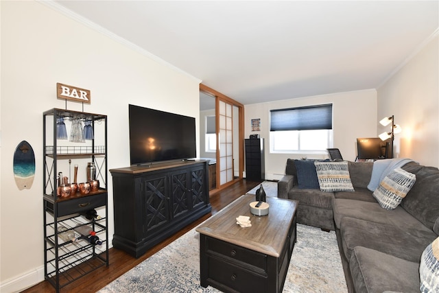 living area with ornamental molding, wood finished floors, and baseboards