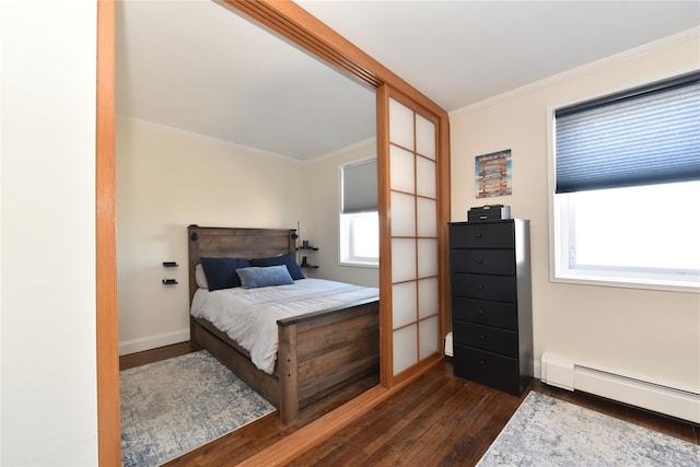 bedroom featuring baseboards, a baseboard heating unit, dark wood-style flooring, and crown molding