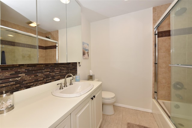 full bathroom featuring toilet, bath / shower combo with glass door, vanity, baseboards, and tasteful backsplash