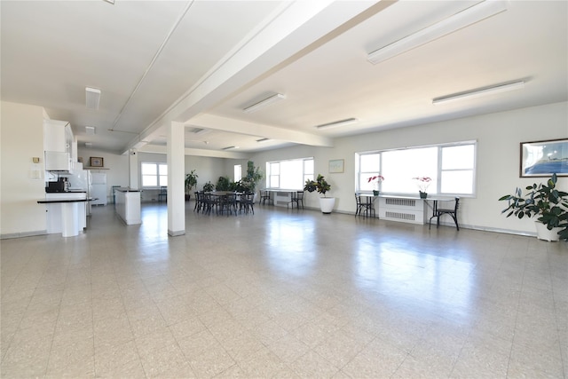 interior space featuring radiator heating unit, baseboards, and light floors