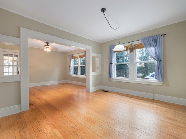 unfurnished dining area with a ceiling fan, light wood-style flooring, visible vents, and baseboards