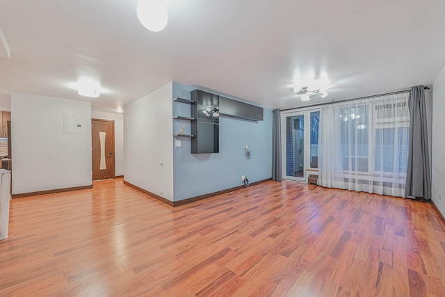 unfurnished living room featuring baseboards and light wood-style floors