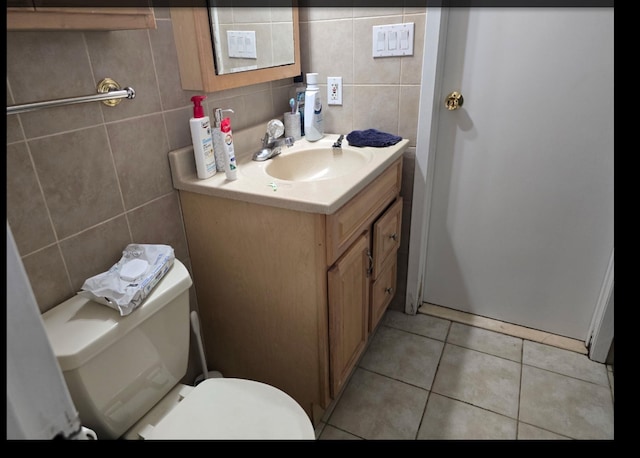 half bath featuring vanity, tile walls, toilet, and tile patterned floors