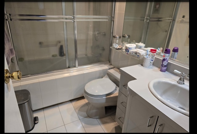 full bath featuring tiled shower / bath combo, vanity, toilet, and tile patterned floors