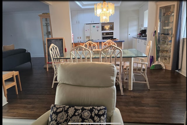 dining room with dark wood-style floors, a chandelier, crown molding, and baseboards