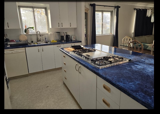 kitchen featuring a sink, white cabinets, dishwasher, dark countertops, and stainless steel gas stovetop