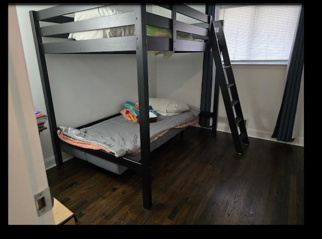 bedroom with baseboards and wood finished floors