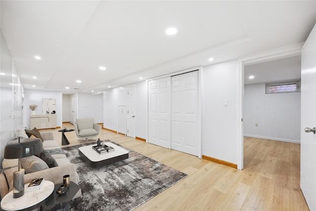 living room featuring light wood-type flooring, baseboards, and recessed lighting