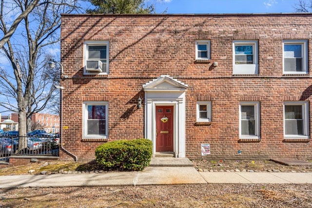 multi unit property featuring cooling unit and brick siding