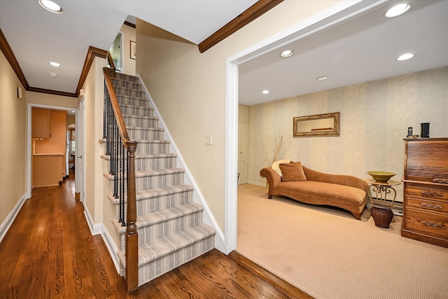 stairway featuring recessed lighting, crown molding, baseboards, and wood finished floors