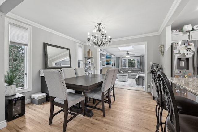 dining area featuring crown molding, light wood-type flooring, and a chandelier