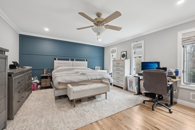 bedroom featuring wood finished floors, visible vents, baseboards, ceiling fan, and ornamental molding