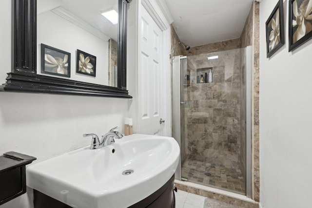 bathroom with tile patterned floors, vanity, a stall shower, and crown molding