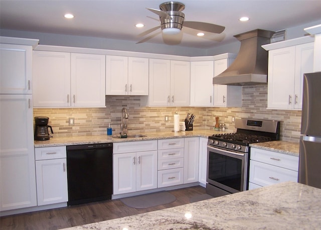 kitchen with ceiling fan, stainless steel appliances, a sink, white cabinetry, and wall chimney exhaust hood