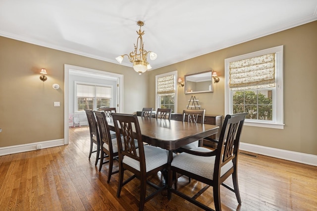 dining area with baseboards, a notable chandelier, visible vents, and hardwood / wood-style floors