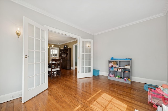 game room with french doors, crown molding, baseboards, and wood finished floors