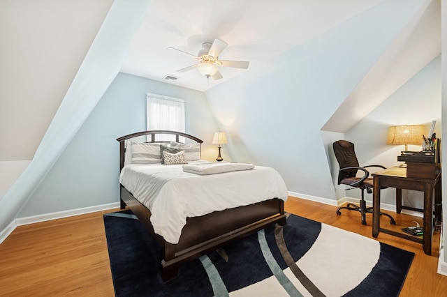 bedroom with lofted ceiling, visible vents, ceiling fan, wood finished floors, and baseboards