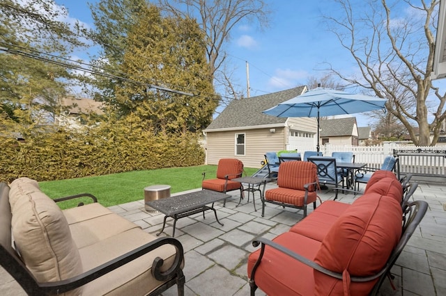 view of patio / terrace featuring an outbuilding, outdoor dining area, fence, and an outdoor hangout area