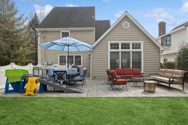 rear view of house featuring a lawn, an outdoor hangout area, roof with shingles, fence, and a patio area