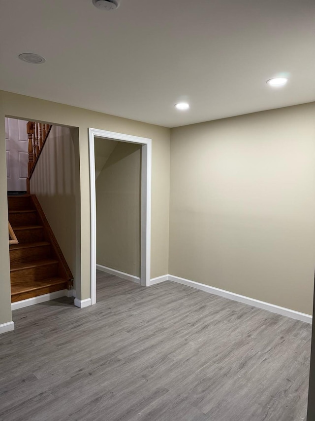 below grade area featuring stairway, recessed lighting, baseboards, and wood finished floors