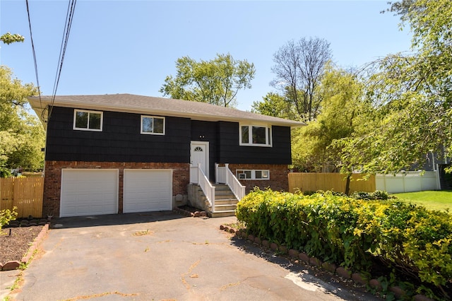 30 Bushwick Ave, Brentwood, NY 11717 - split foyer home with asphalt driveway, an attached garage, and brick siding