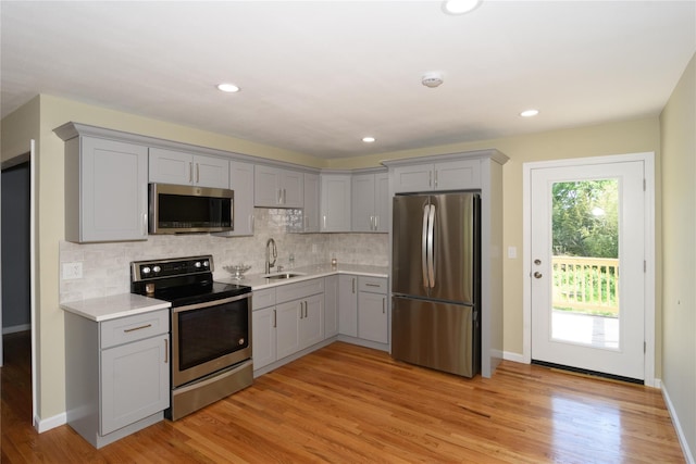 30 Bushwick Ave, Brentwood, NY 11717 - kitchen featuring stainless steel appliances, gray cabinetry, a sink, light countertops, and light wood finished floors