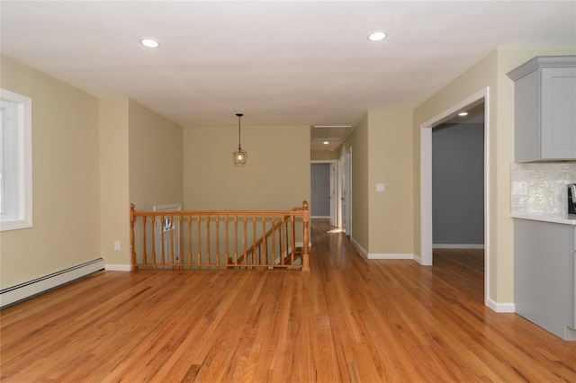 30 Bushwick Ave, Brentwood, NY 11717 - empty room with light wood finished floors, a baseboard radiator, recessed lighting, and baseboards
