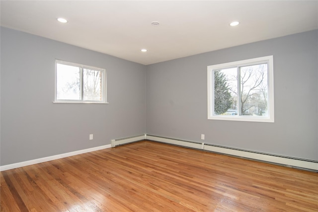 30 Bushwick Ave, Brentwood, NY 11717 - empty room with healthy amount of natural light, light wood finished floors, recessed lighting, baseboards, and a baseboard radiator