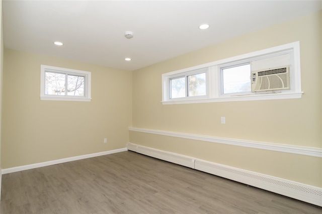 30 Bushwick Ave, Brentwood, NY 11717 - below grade area featuring baseboard heating, plenty of natural light, wood finished floors, and recessed lighting