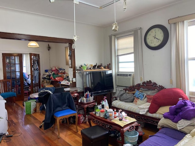 living room with hardwood / wood-style floors, cooling unit, and a healthy amount of sunlight