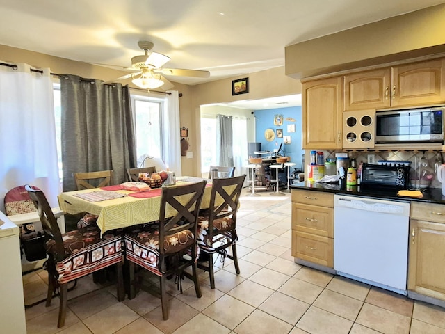 kitchen featuring light tile patterned floors, a ceiling fan, stainless steel microwave, white dishwasher, and light brown cabinets