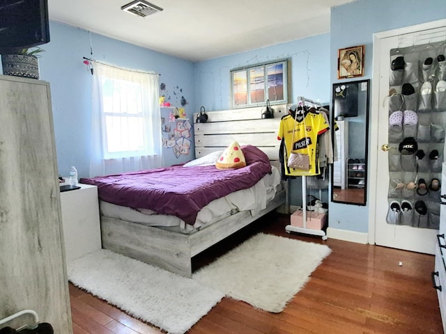 bedroom with visible vents and wood finished floors