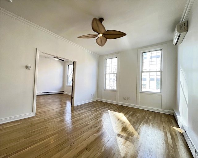 empty room featuring a baseboard heating unit, an AC wall unit, ceiling fan, wood finished floors, and baseboards