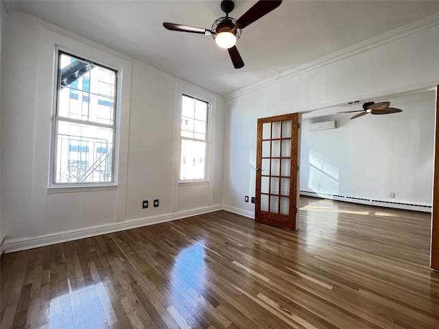 empty room featuring a wall unit AC, a baseboard heating unit, wood finished floors, baseboards, and crown molding