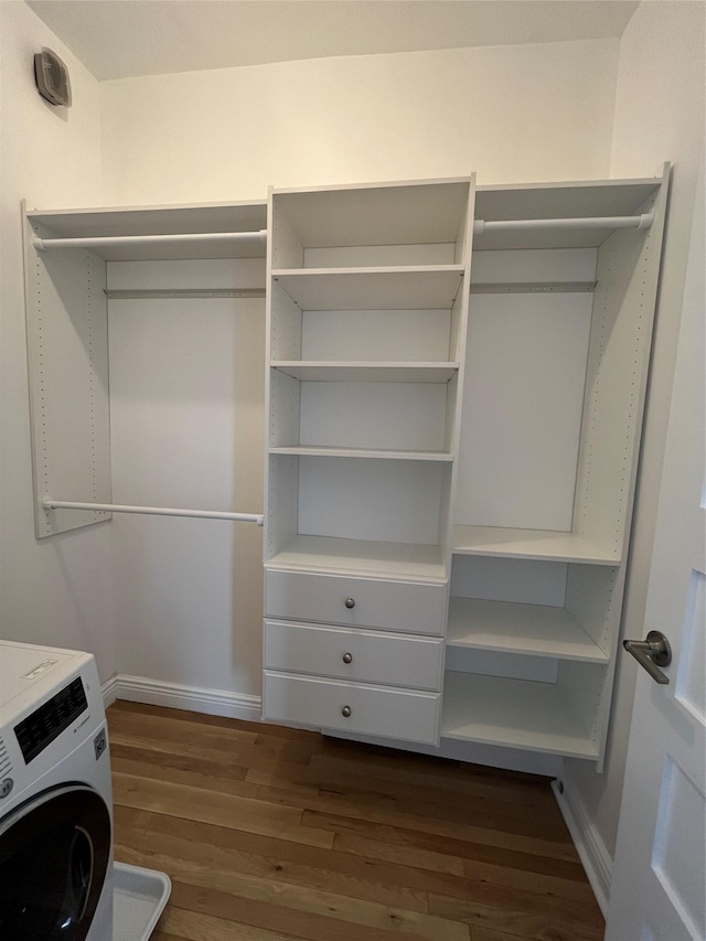 laundry area with dark wood-style flooring, washer / dryer, and baseboards