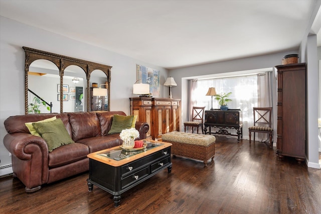 living room with a baseboard heating unit and dark wood-style flooring