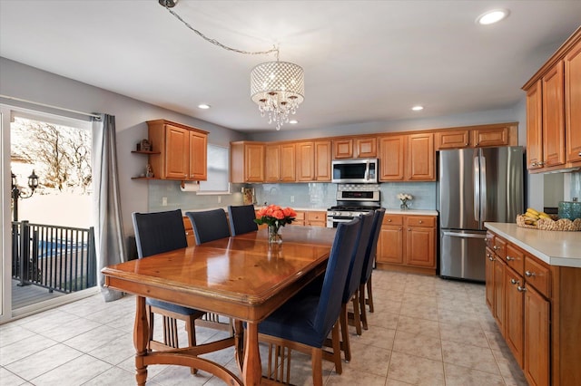 kitchen featuring decorative backsplash, brown cabinets, appliances with stainless steel finishes, and light countertops