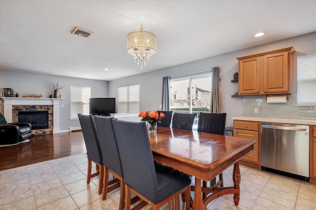 dining space with light tile patterned floors, plenty of natural light, visible vents, and an inviting chandelier