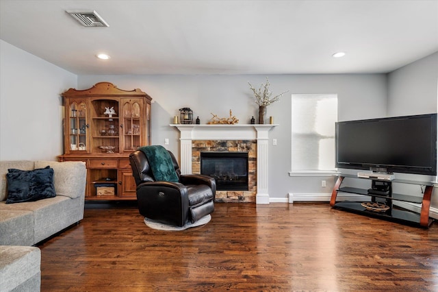 living area with a fireplace, recessed lighting, wood finished floors, and visible vents