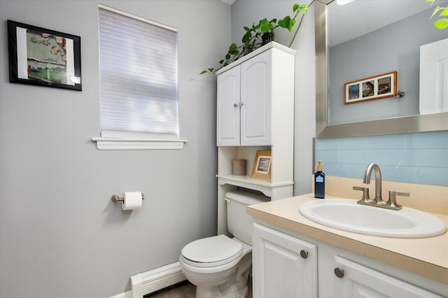 half bathroom with tasteful backsplash, toilet, vanity, and a baseboard radiator