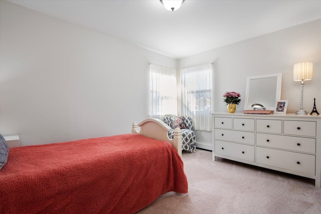 bedroom with light carpet and baseboard heating