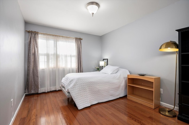 bedroom featuring baseboards and hardwood / wood-style floors