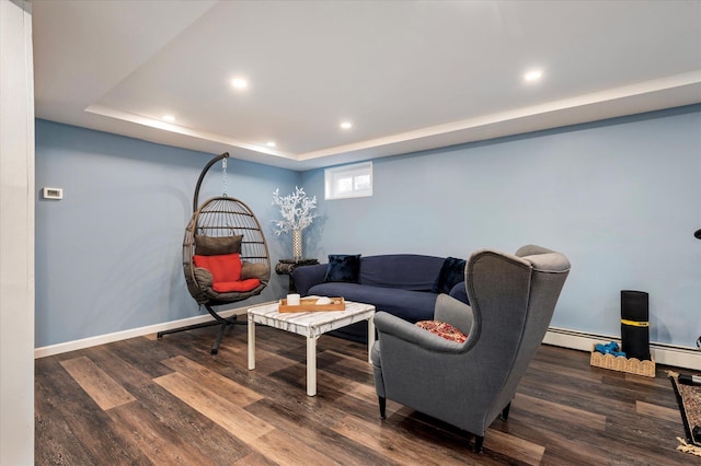 living room with a raised ceiling, recessed lighting, wood finished floors, and baseboards