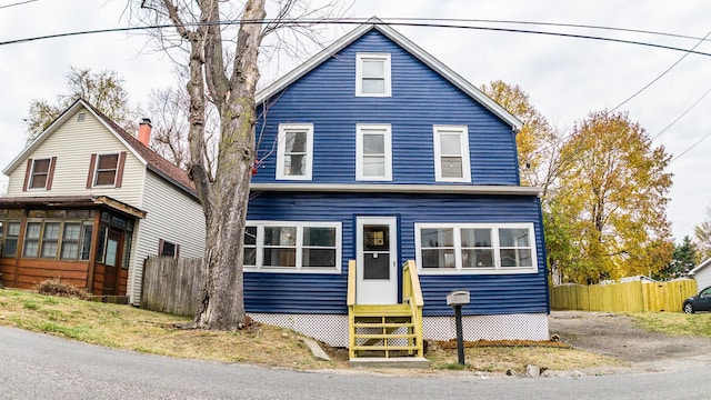 view of front of property with entry steps and fence