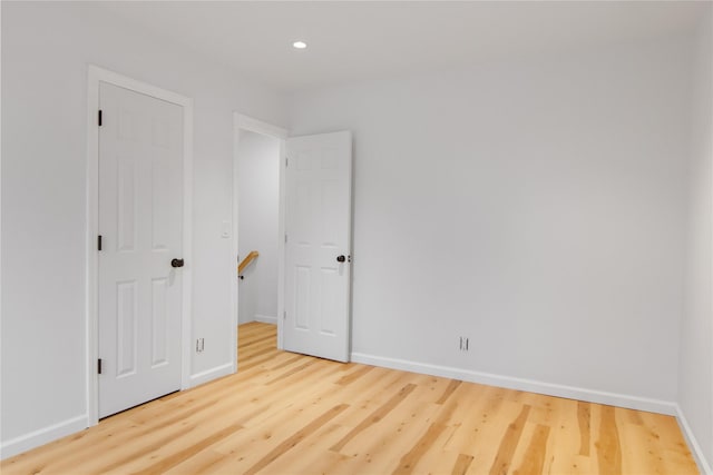 empty room with recessed lighting, baseboards, and wood finished floors