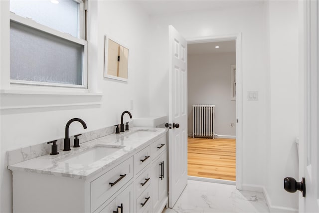 full bathroom featuring marble finish floor, radiator heating unit, baseboards, and a sink