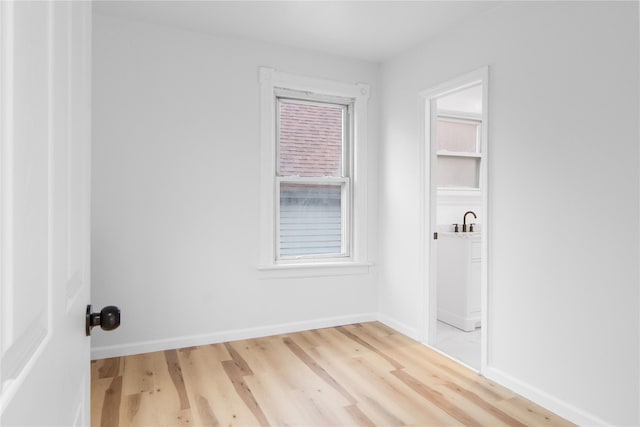 washroom with baseboards and light wood-style floors