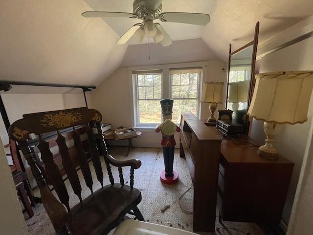 sitting room with a ceiling fan and vaulted ceiling