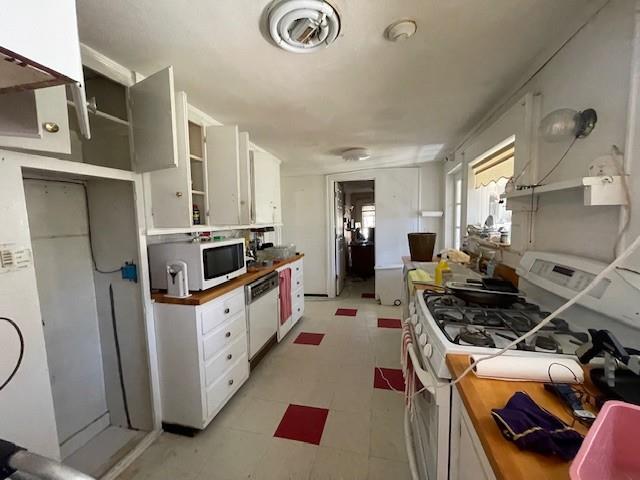 kitchen with white appliances, white cabinets, butcher block counters, light floors, and open shelves